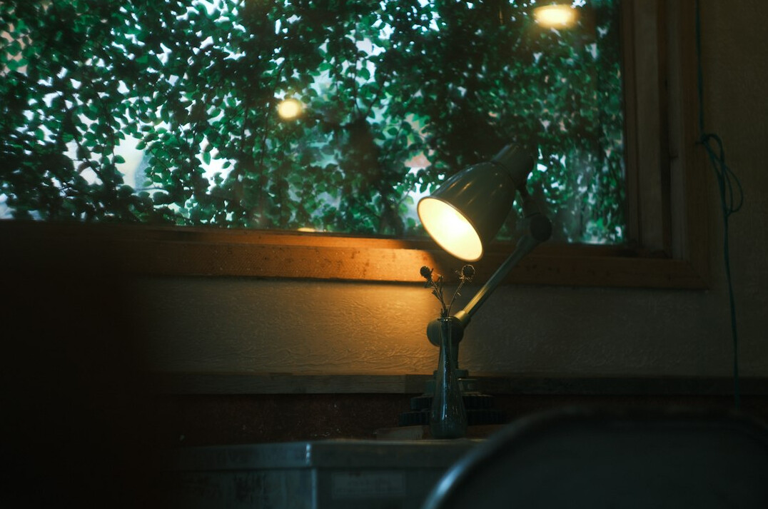Cosy reading nook with magazines and a warm lamp by a window