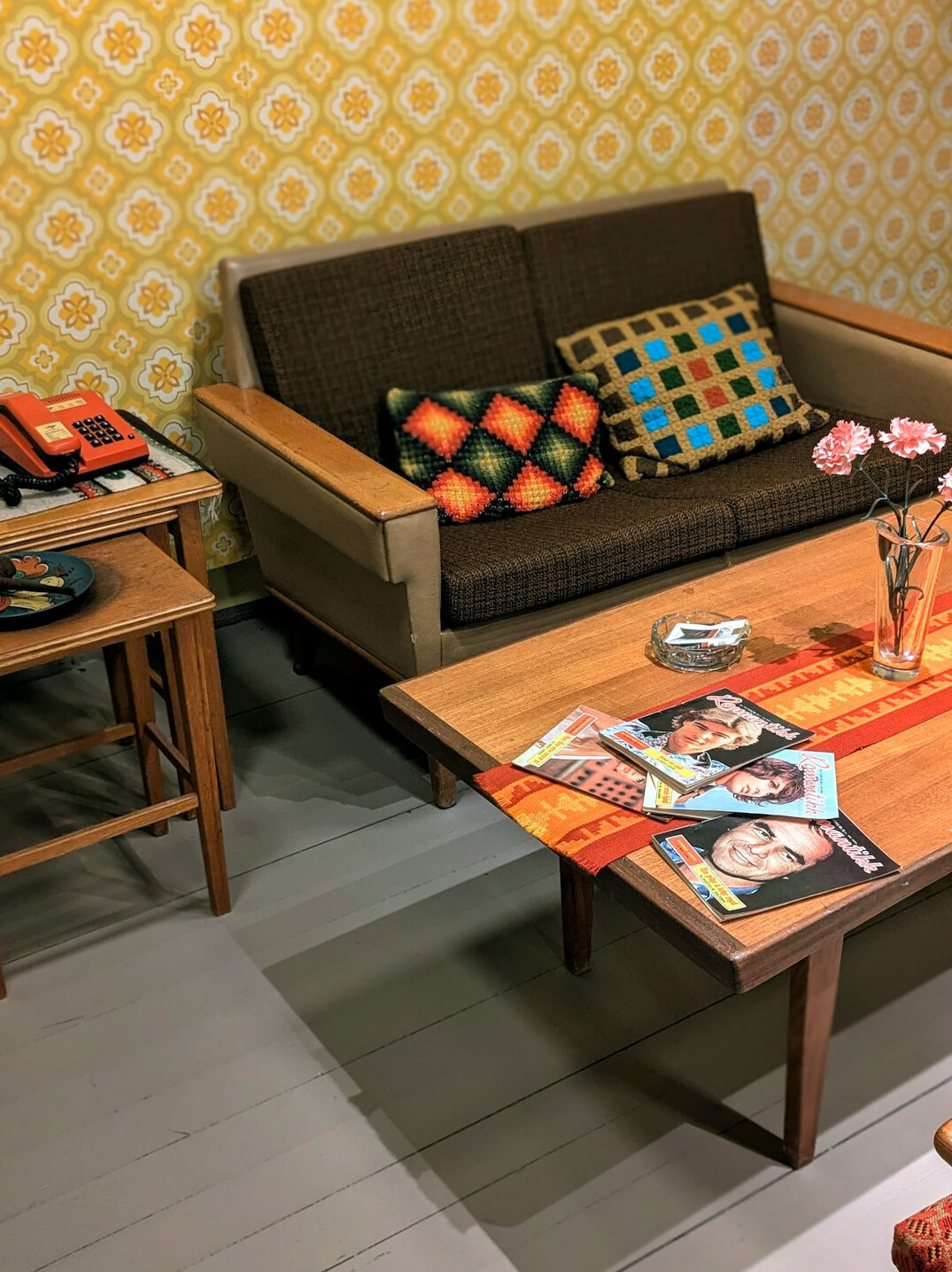 Retro 1980s lounge with bold patterned wallpaper and vintage furniture